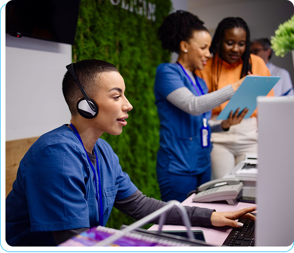Healthcare professionals collaborating at a reception desk.
