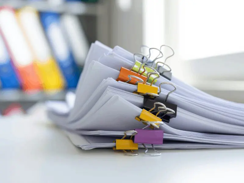 Stack of papers with colorful binder clips.