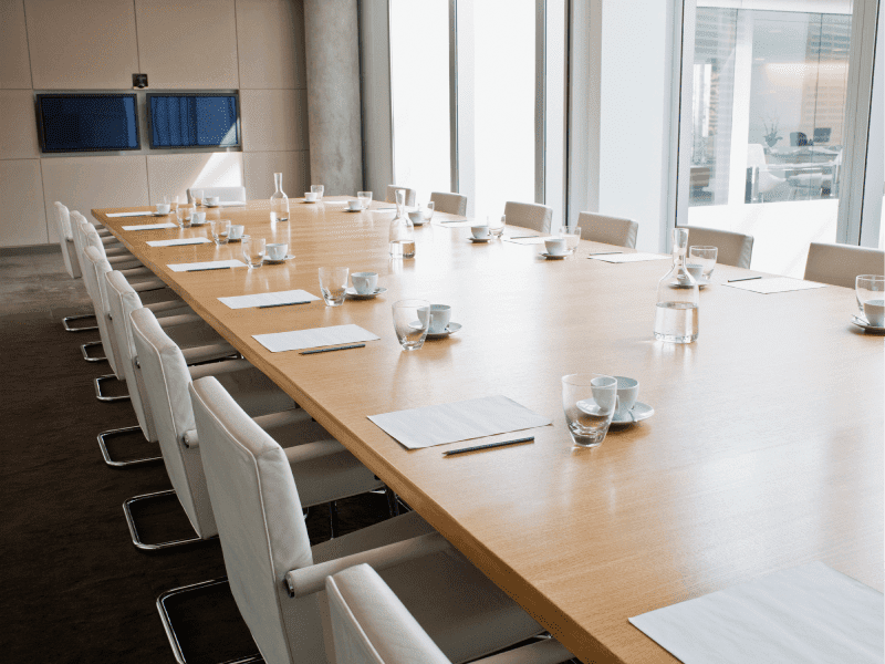 Empty conference room with long wooden table.